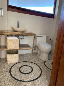 un bagno con un water bianco e un lavandino di Luana Suites- Suite Aruma a Zihuatanejo