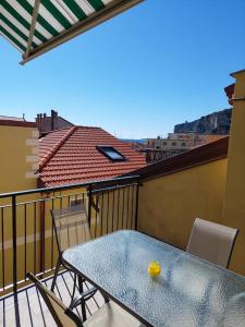 een tafel en stoelen op een balkon met uitzicht op een dak bij Casa Pamy- Bike Friendly 9029LT1161 in Finale Ligure