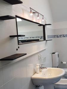 een badkamer met een wastafel, een spiegel en een toilet bij Casa Pamy- Bike Friendly 9029LT1161 in Finale Ligure