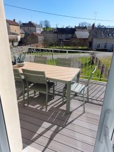 a wooden table and chairs on a deck at Maison art de vivre in Fresnay-sur-Sarthe