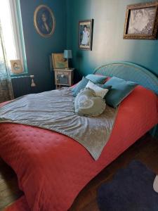 a bedroom with a large bed with a red blanket at Maison art de vivre in Fresnay-sur-Sarthe