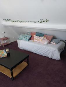 a couch with pillows on it in a room at Maison art de vivre in Fresnay-sur-Sarthe