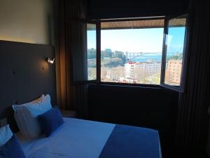 Vilar Oporto Hotel في بورتو: غرفة نوم بسرير ونافذة كبيرة