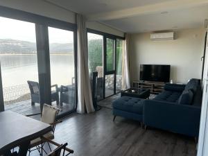 a living room with a blue couch and a television at Exclusive Bungalow by the Sea in Bandırma