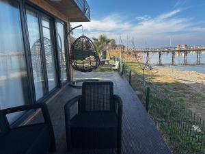 een veranda met 2 stoelen, een schommel en een pier bij Exclusive Bungalow by the Sea in Bandırma