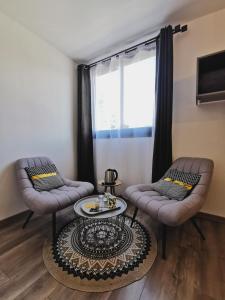 - un salon avec deux chaises et une table dans l'établissement Côté Volcan, à La Plaine des Cafres