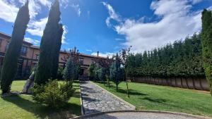 un jardín con árboles y una pasarela de piedra en Palacio del Conde de Rebolledo, en Villaviciosa de la Ribera