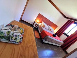 mały pokój z łóżkiem i stołem w obiekcie Côté Volcan w mieście La Plaine des Cafres