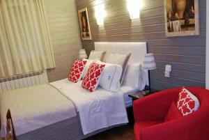 a bedroom with a bed and a red chair at Hostal Martin - Sanabria in Ribadelago