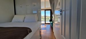 um quarto com uma cama e uma porta para uma varanda em Floating Experience - Casa flutuante a 25 min do Porto em Póvoa de Varzim