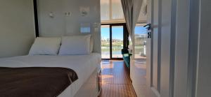 a bedroom with a bed and a door to a balcony at Floating Experience - Casa flutuante a 25 min do Porto in Póvoa de Varzim +37 photos