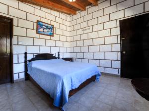 um quarto com uma cama numa parede de tijolos em Hotel Quinta Mirador Zacualli em Bernal