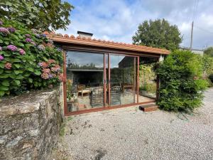 a garden room with glass windows and a patio at Lugar do Curro, San Martiño de Ozón in Muxia