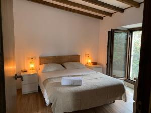 - une chambre avec un grand lit et 2 lampes dans l'établissement Lugar do Curro, San Martiño de Ozón, à Muxía