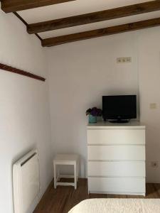 a room with a tv on top of a dresser at Lugar do Curro, San Martiño de Ozón in Muxia
