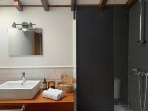a bathroom with a sink and a mirror and a shower at Lugar do Curro, San Martiño de Ozón in Muxia +23 photos