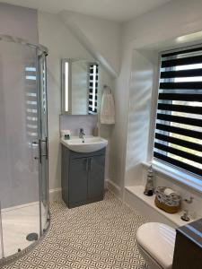 uma casa de banho com um lavatório e um chuveiro em Burnbank BnB em Tobermory