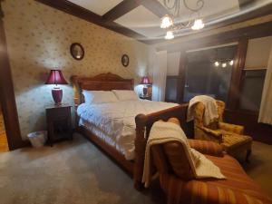 a bedroom with a large bed and a chair at The Weis Mansion Bed and Breakfast in Waterloo