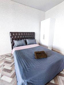 een slaapkamer met een groot bed en een blauw dekbed bij Апартаменты в новостройке по Байзакова 131/1 in Pavlodar