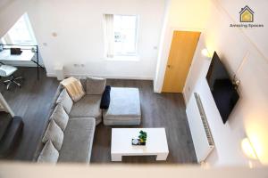 a living room with a couch and a table at LARGE UNIQUE 2 BEDROOM DUPLEX APARTMENT WITH PRIVATE PARKING & FREE WIFI - VAT QUALIFYING BY AMAZING SPACES RELOCATIONS Ltd in Warrington