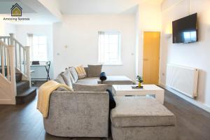 a living room with a couch and a tv at LARGE UNIQUE 2 BEDROOM DUPLEX APARTMENT WITH PRIVATE PARKING & FREE WIFI - VAT QUALIFYING BY AMAZING SPACES RELOCATIONS Ltd in Warrington