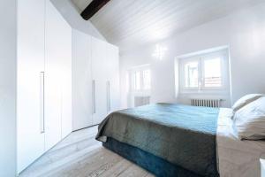 a white bedroom with a bed and a window at Loft Cavour - Teatro Ariston in Sanremo