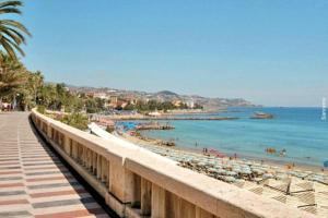 a beach with umbrellas and people in the water at Loft Cavour - Teatro Ariston in Sanremo