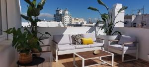 a balcony with a couch and two chairs and a table at el 2 de Flamenco Ático 3ºB in Cádiz