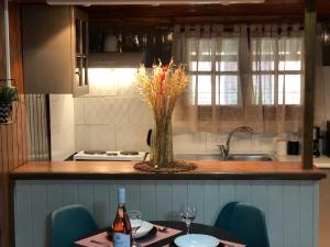 a kitchen with a table with a vase of flowers on it at Cozy Home Kanali, Preveza in Kanali