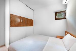 1 dormitorio con cama blanca y ventana en Amaryllis 1-Svoronata Village, en Svoronata