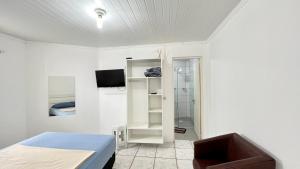 Habitación blanca con cama y ducha en kitnet Revitalize I, en Torres