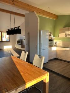 uma cozinha com uma mesa de madeira e electrodomésticos brancos em FeWo Krämer em Plein
