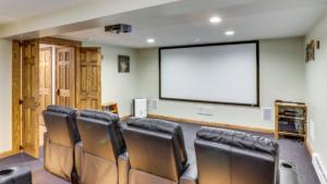 une salle de conférence avec des chaises et un grand écran dans l'établissement Two Much Fun, à Swanton