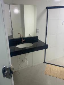 a bathroom with a sink and a mirror at Hotel Porto Brasília in Porto Seguro