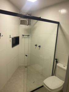 a bathroom with a glass shower with a toilet at Hotel Porto Brasília in Porto Seguro