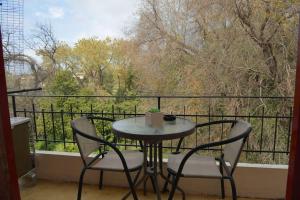 una mesa y sillas en un balcón con vistas en little apartment in kanoni en Análipsis