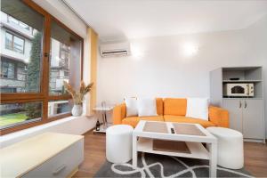 sala de estar con sofá naranja y mesa en Snow Legend Apartment with terrace en Bansko