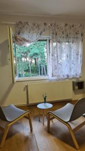 um quarto com duas cadeiras, uma mesa e uma janela em Apartment Una em Bjelovar