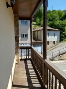 balcón con vistas a una casa y a la piscina en CASONA SARIEGO, APARTAMENTO en La Vega de Riosa