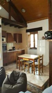 uma cozinha com uma mesa e cadeiras e um frigorífico branco em CASONA SARIEGO, APARTAMENTO em La Vega de Riosa