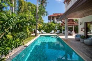 a swimming pool in the backyard of a villa at Beachfront Resort Villa Baan Tawan 3BR in Lamai