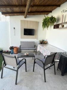 un patio con 2 sedie, un tavolo e una TV di Um Paraíso em Paripueira a Paripueira