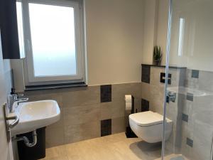 a bathroom with a toilet and a sink at Neubauwohnung im Herzen Panketal in Panketal