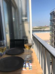 una mesa con 2 copas de vino en el balcón en TheHeaven@7, en Ostende