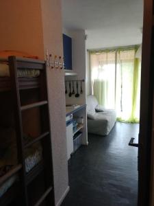 salon z kanapą i oknem w obiekcie Superbe studio dans résidence avec piscine sans chambre mais couchage salle et lit superposé dans l'entrée w mieście Le Grau-du-Roi