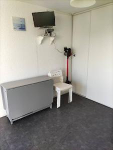 Pokój z telewizorem, stołem i krzesłem w obiekcie Superbe studio dans résidence avec piscine sans chambre mais couchage salle et lit superposé dans l'entrée w mieście Le Grau-du-Roi