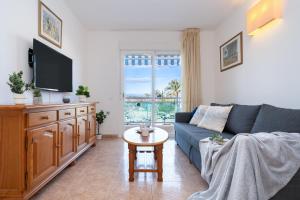 a living room with a blue couch and a table at Alea Rentals - Los Juncos in La Pineda