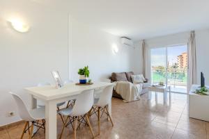 a white dining room with a white table and chairs at Alea Rentals - Los Juncos in La Pineda