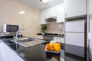 a kitchen with a sink and a plate of fruit on a counter at Alea Rentals - Los Juncos in La Pineda