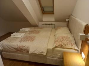 a bed in a small room with two towels on it at Vila Borova Zlatibor Apartman 501 in Zlatibor